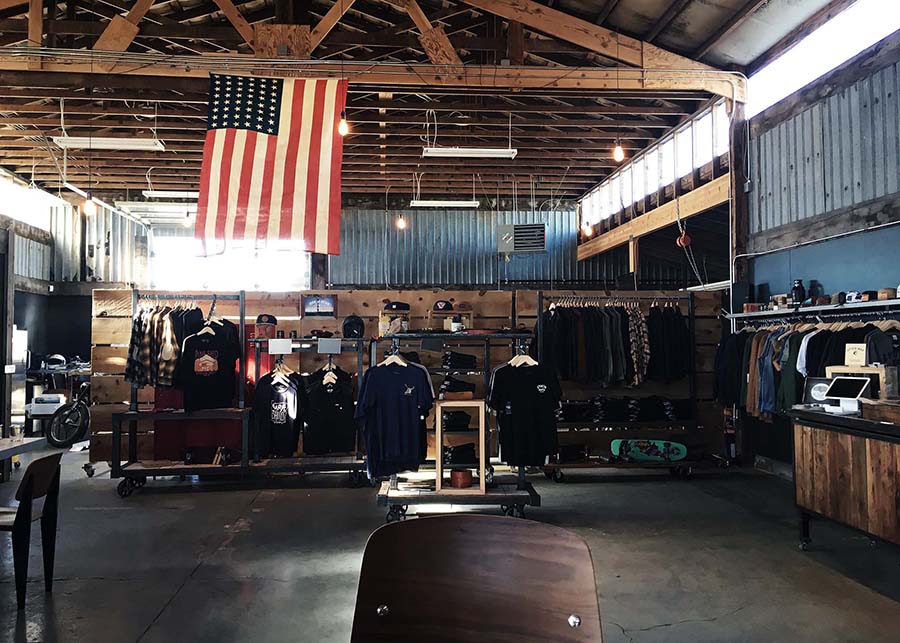 Looking into the garage shop a large flag hangs from the ceiling above the retail floor, the wooden roof frame exposed